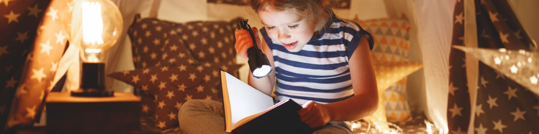 Child reading in tent